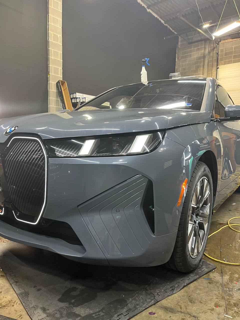 A 2026 BMW iX with full front STEK DYNOshield paint protection film and ceramic coating installed at Skyline Custom Shop in Chantilly, VA.